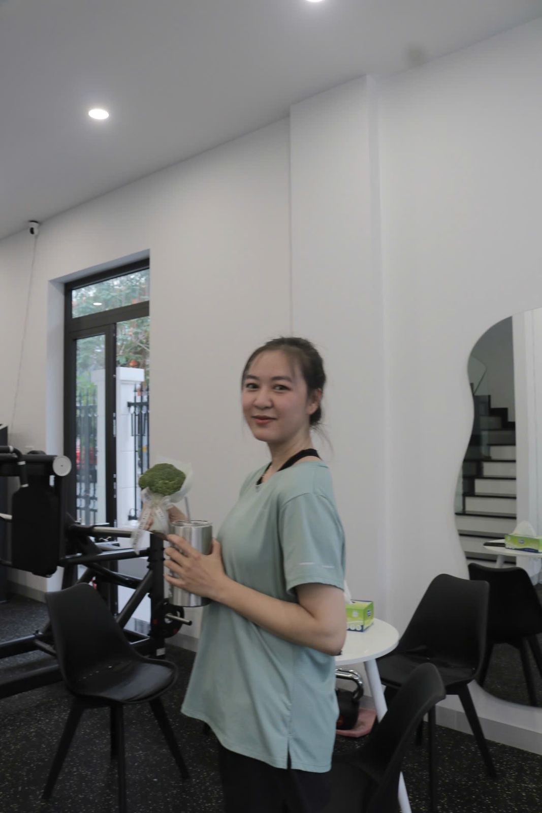 Học viên mỉm cười cầm ly nước sau buổi tập